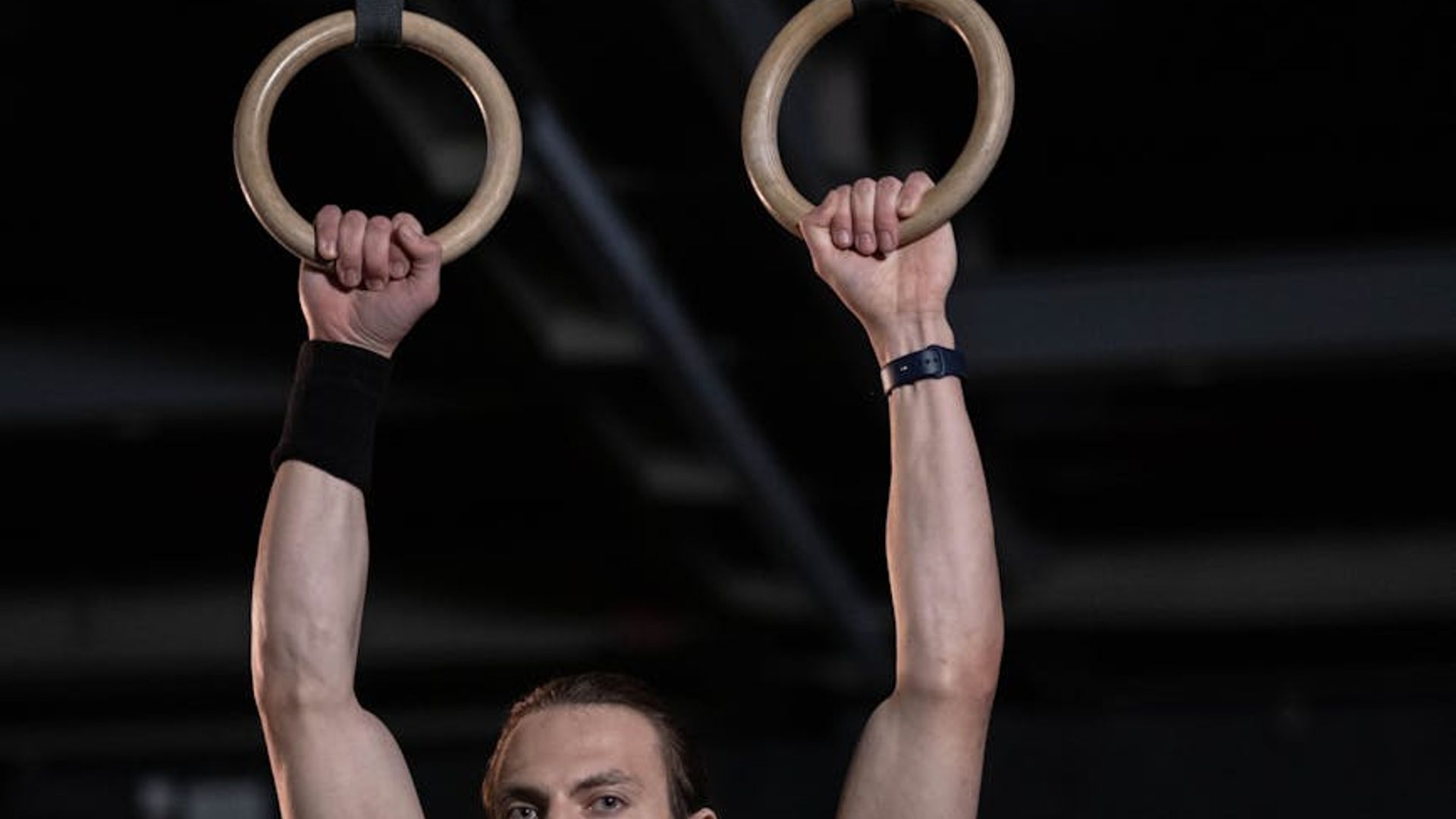 Man performing a steady strength exercise in a modern gym